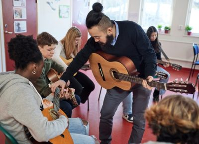 stock-photo-teenagers-attending-guitar-lesson-from-the-offset-collection-2154351123-transformed